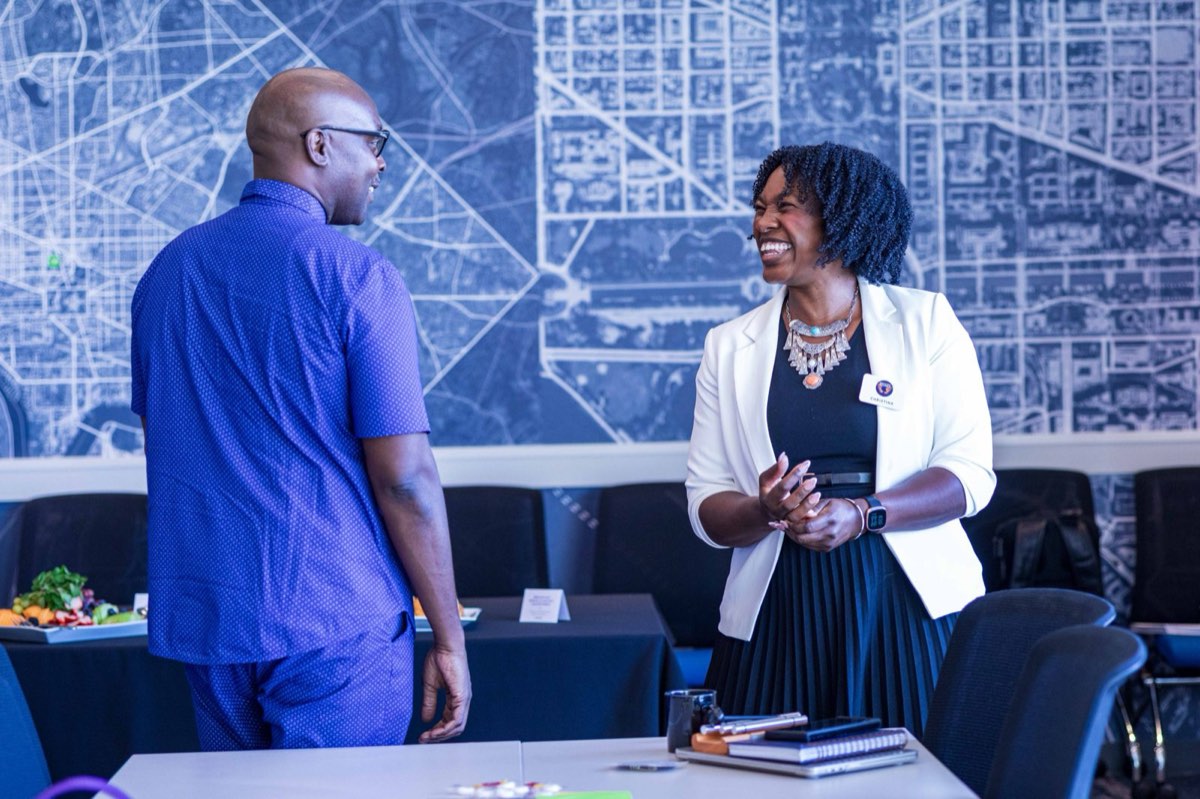 Christina Scott laughing in conversation with a participant at a leadership session